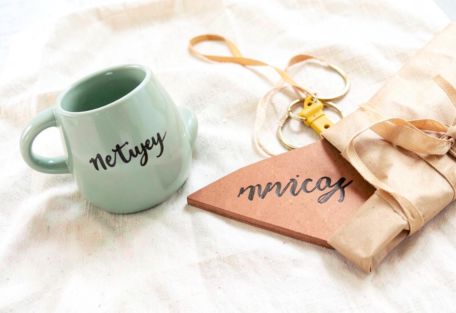 Handmade personalised mug, wooden plaque, keyrings and gift wrap on cream linen